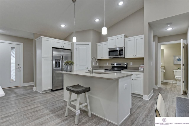 kitchen with white cabinets, stainless steel appliances, and decorative light fixtures