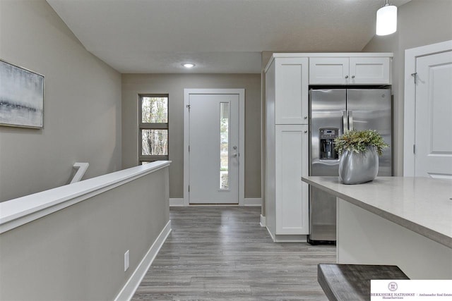 foyer with a textured ceiling and light wood-type flooring