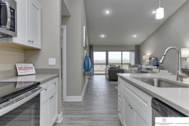 kitchen featuring appliances with stainless steel finishes, sink, light hardwood / wood-style floors, and white cabinets