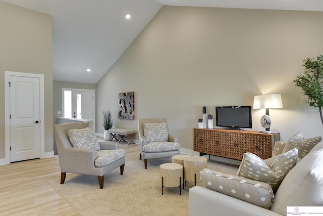 living room with high vaulted ceiling and light hardwood / wood-style floors