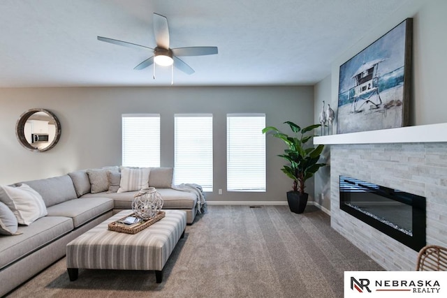 living room featuring carpet flooring, a tiled fireplace, and ceiling fan