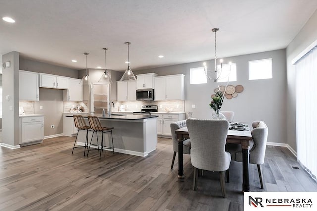 dining room featuring hardwood / wood-style flooring, an inviting chandelier, and sink