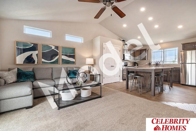 living room featuring high vaulted ceiling, carpet, ceiling fan, and sink