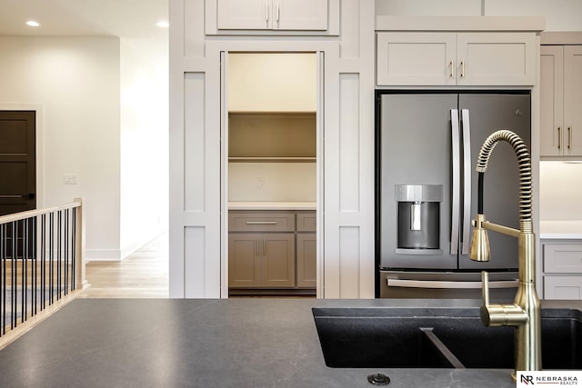 kitchen featuring light hardwood / wood-style floors, sink, stainless steel fridge, and gray cabinetry