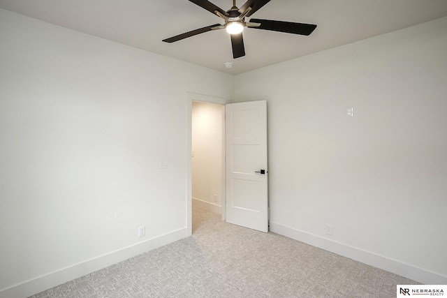 spare room featuring light carpet and ceiling fan