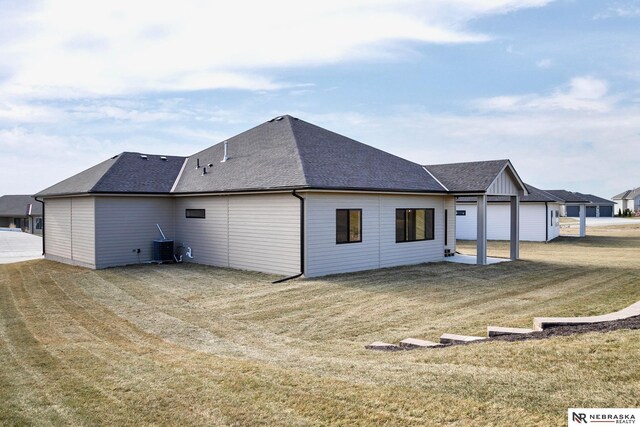 back of house with a lawn and a garage