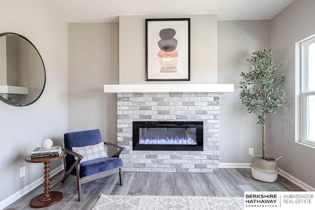 sitting room featuring a wealth of natural light, wood-type flooring, and a fireplace