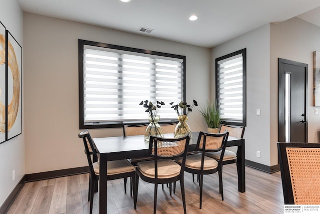 dining room featuring a healthy amount of sunlight and light hardwood / wood-style flooring