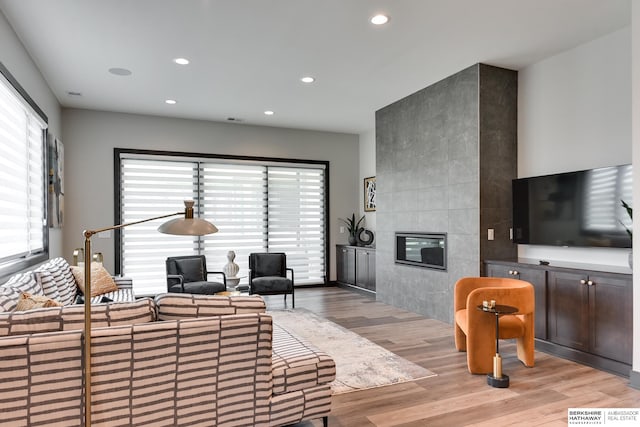 living room featuring light hardwood / wood-style floors and a tile fireplace