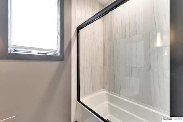 bathroom featuring bath / shower combo with glass door