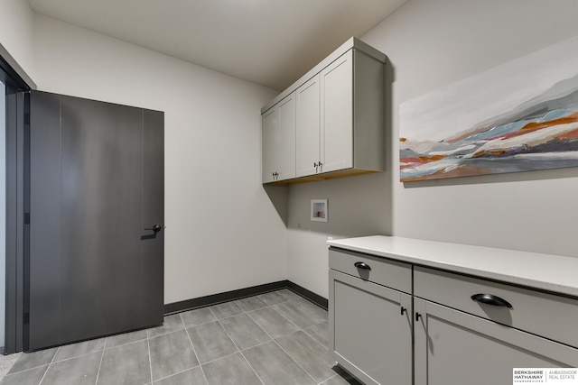 washroom with light tile floors, cabinets, and hookup for a washing machine