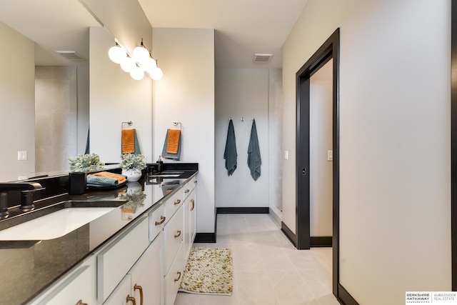 bathroom with oversized vanity, tile floors, and dual sinks