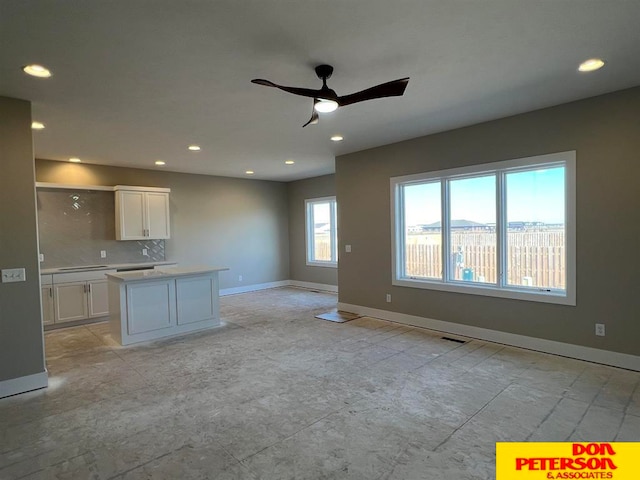 kitchen featuring light tile floors, white cabinets, backsplash, and ceiling fan