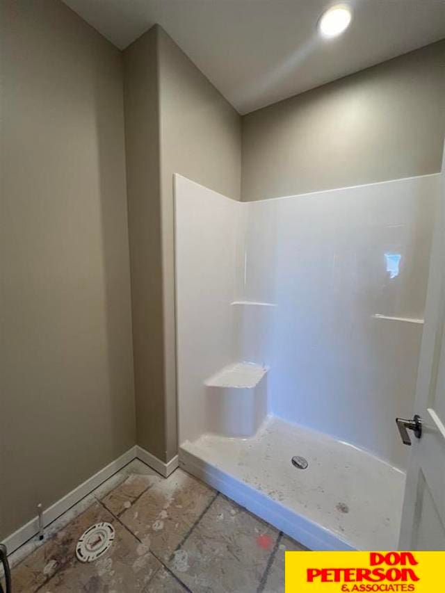 bathroom with a shower and tile floors