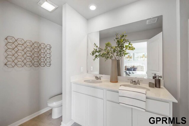 bathroom featuring dual bowl vanity, toilet, and tile flooring