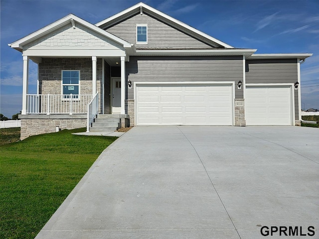 craftsman house featuring a porch, a front lawn, and a garage