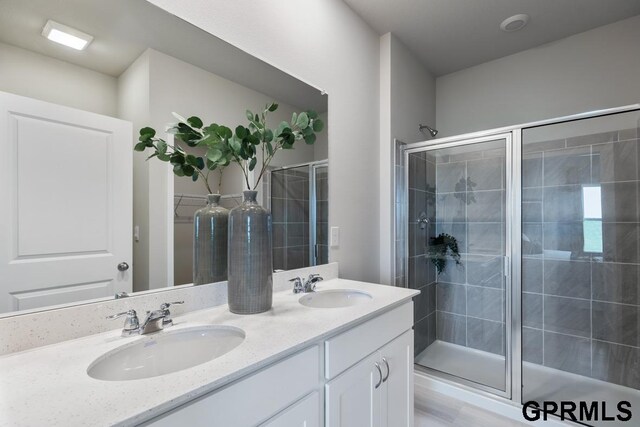 bathroom featuring dual vanity and walk in shower