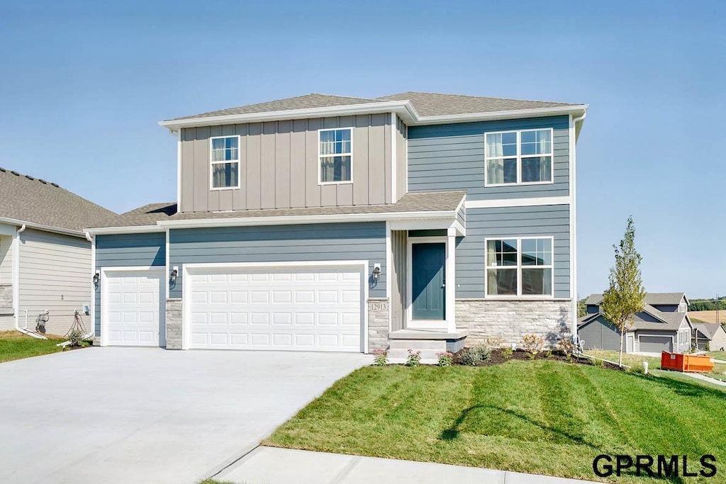 view of front of property featuring a front lawn and a garage