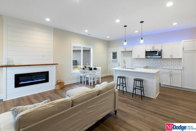 living room featuring dark hardwood / wood-style floors, sink, and a fireplace