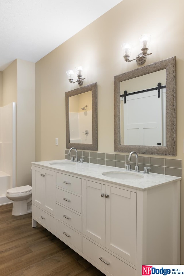 bathroom with hardwood / wood-style floors, toilet, and dual vanity