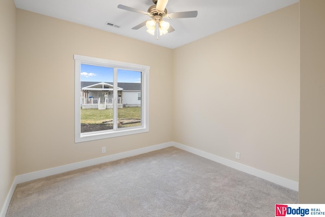 empty room featuring light carpet, ceiling fan, and a wealth of natural light