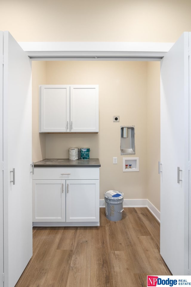 clothes washing area with light hardwood / wood-style floors, cabinets, electric dryer hookup, and hookup for a washing machine