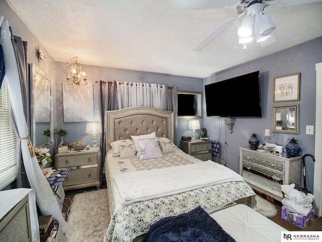 bedroom with carpet flooring, a textured ceiling, and ceiling fan with notable chandelier