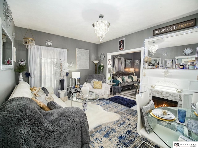 living room with a premium fireplace and an inviting chandelier