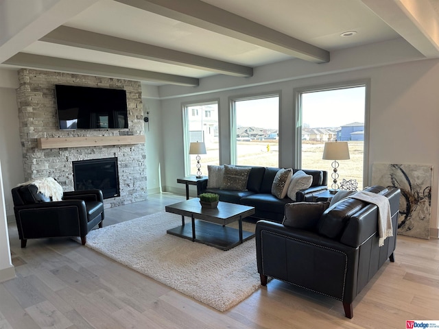 living room with beam ceiling, a fireplace, and light hardwood / wood-style floors