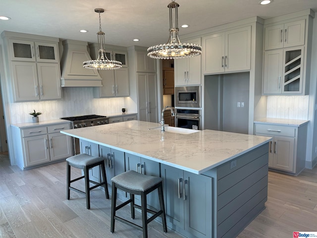 kitchen with sink, stainless steel appliances, a spacious island, gray cabinets, and custom exhaust hood