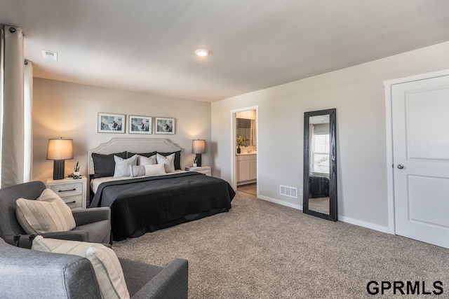 carpeted bedroom featuring ensuite bath