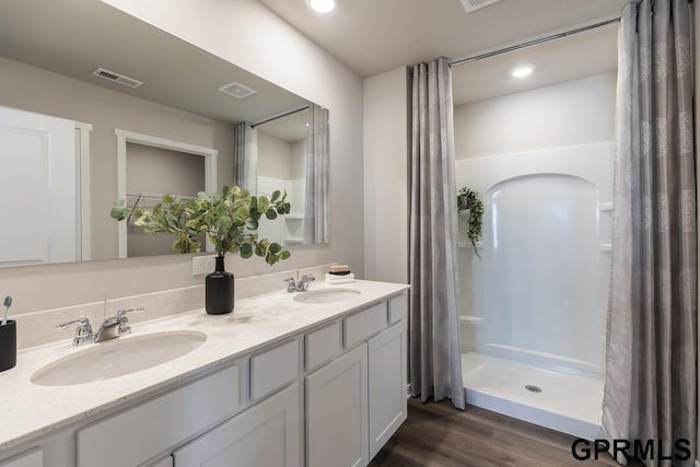 bathroom featuring a shower with curtain, wood-type flooring, double sink, and large vanity