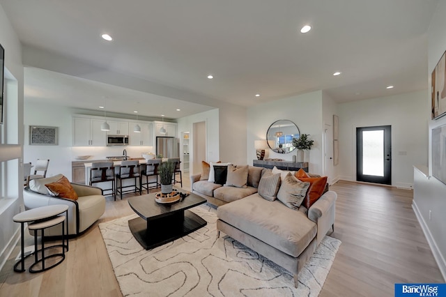 living room featuring sink and light wood-type flooring