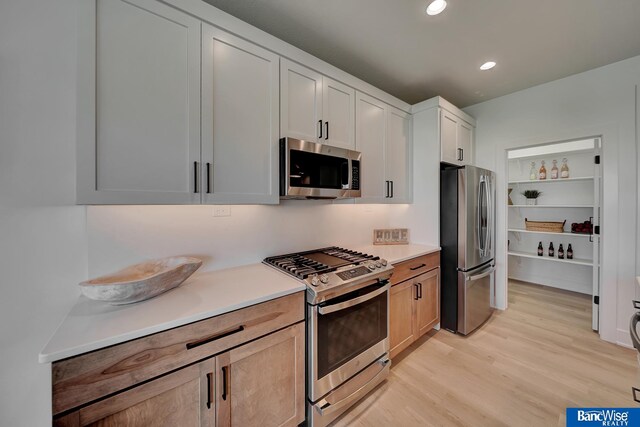 kitchen featuring white cabinetry, stainless steel appliances, and light hardwood / wood-style floors