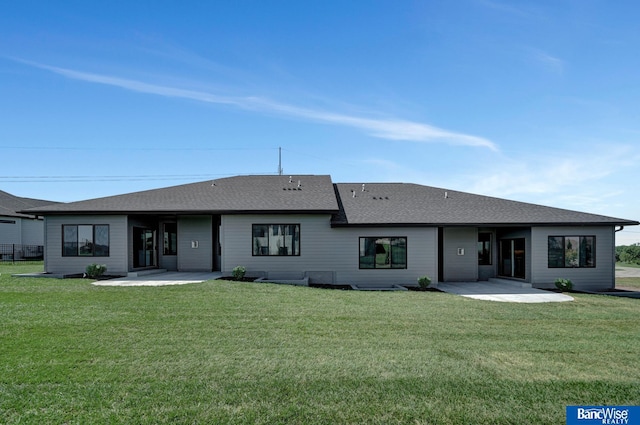 rear view of house with a patio area and a lawn