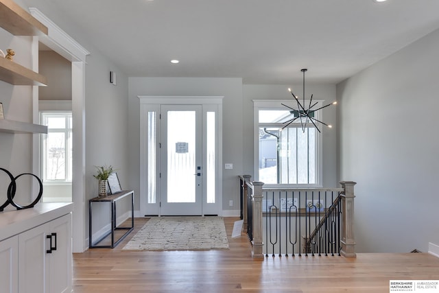 foyer entrance with a notable chandelier and light wood-type flooring