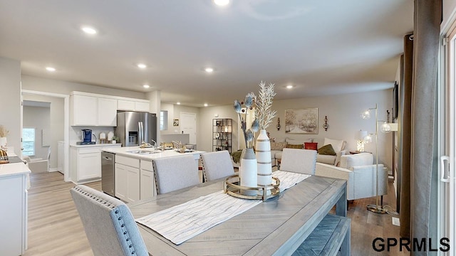 dining room with sink and light hardwood / wood-style flooring