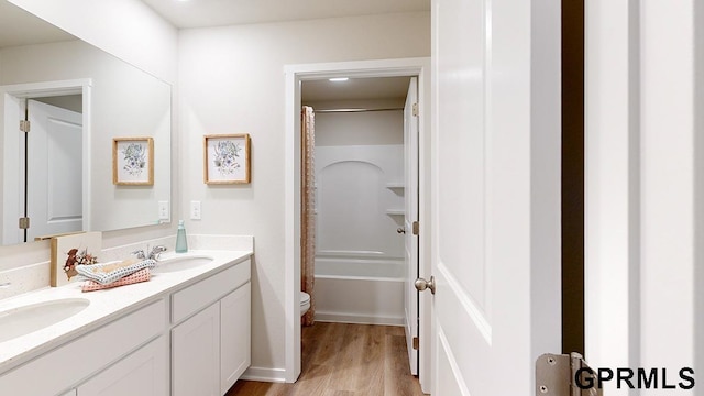 full bathroom featuring shower / bathtub combination with curtain, dual vanity, toilet, and hardwood / wood-style floors