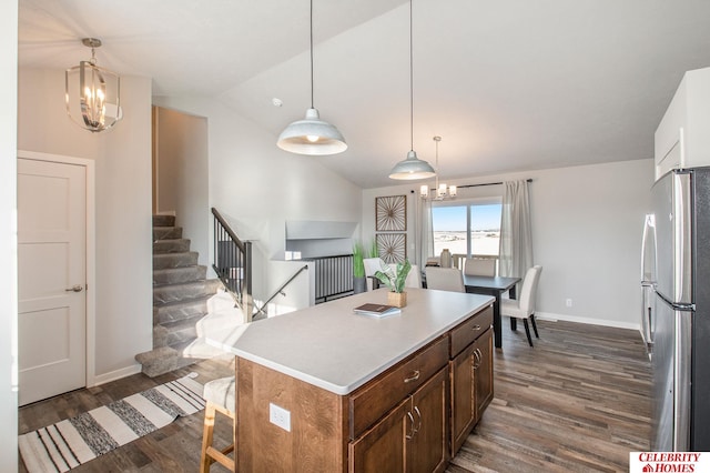 kitchen featuring a chandelier, dark wood-type flooring, stainless steel refrigerator, and hanging light fixtures