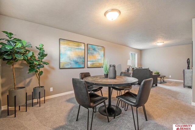 dining space with carpet floors and a textured ceiling