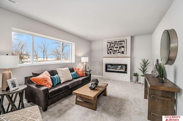 living room with a stone fireplace and carpet floors