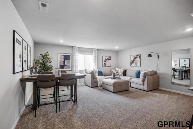 living room with a textured ceiling and carpet flooring