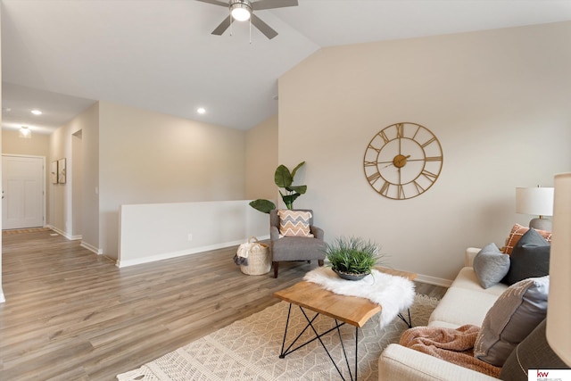 living room featuring vaulted ceiling, light hardwood / wood-style flooring, and ceiling fan