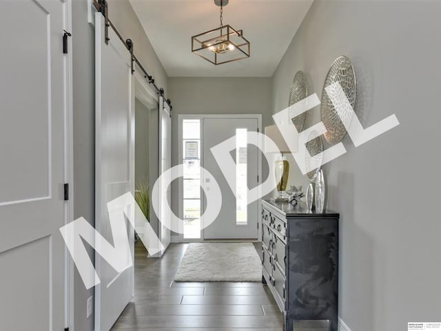 entrance foyer with a chandelier, a barn door, and dark hardwood / wood-style flooring