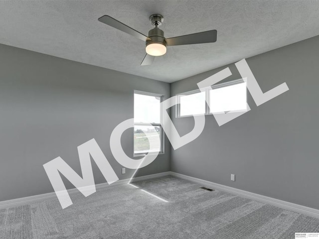 carpeted empty room with ceiling fan and a textured ceiling