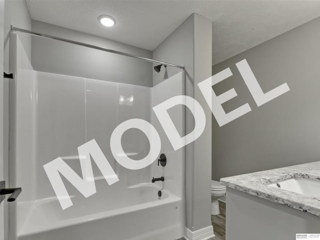 full bathroom featuring shower / washtub combination, vanity, hardwood / wood-style floors, toilet, and a textured ceiling