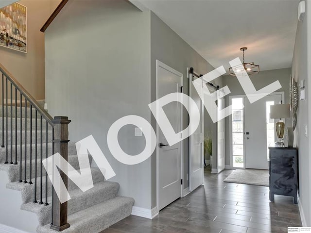 entryway with dark hardwood / wood-style flooring and a towering ceiling