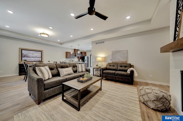 living room with light hardwood / wood-style flooring and ceiling fan