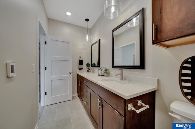 bathroom featuring tile flooring, vanity, and toilet