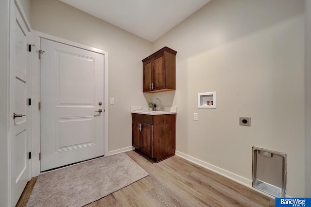 laundry room featuring washer hookup, light hardwood / wood-style flooring, electric dryer hookup, and cabinets